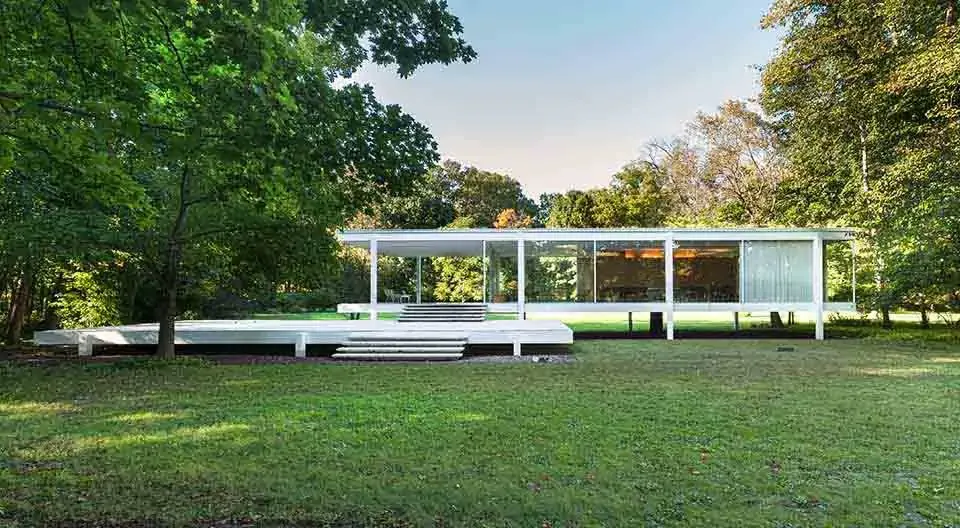 Casa Farnsworth de Mies van der Rohe elevada sobre pilares metálicos e envolvida por vidro
