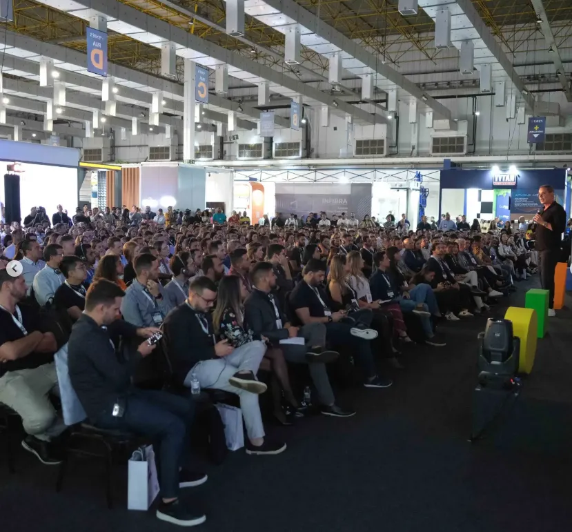 Palestra em evento técnico do ENICS com público acompanhando conteúdo sobre sistemas construtivos industrializados.